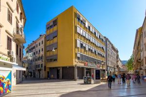 a yellow building in the middle of a street at Apartment Sancti Viti in Rijeka