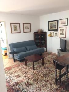 a living room with a blue couch and a table at Appartement près de DOLE in Menotey