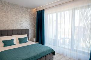 een slaapkamer met een bed en een groot raam bij Bel Air Mamaia Nord -Apartament Delux in Mamaia