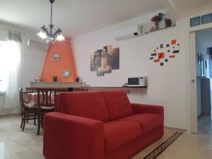 sala de estar con sofá rojo y mesa en ALBA MOZZAFIATO en Lanusei