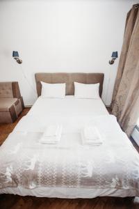 ein großes Bett mit weißer Bettwäsche und Kissen in der Unterkunft Апартаменти для великої компанї в центрі міста in Lwiw