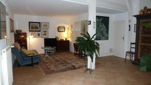 a living room with a couch and a potted plant at Appartement près de DOLE in Menotey