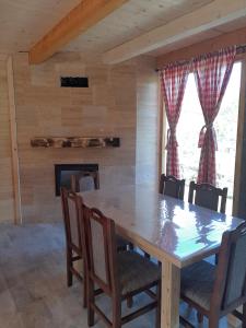 a dining room with a table and chairs and a fireplace at Vikendica Jovičić 2 in Bogutovac