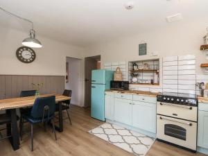 a kitchen with a table and a blue refrigerator at Horsley Cottage in Acharacle