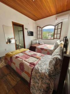 a bedroom with two beds and a window in it at Pouso da Paz in Tiradentes