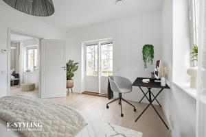 Habitación blanca con escritorio y silla en Accommodation close to Stockholm City, en Estocolmo