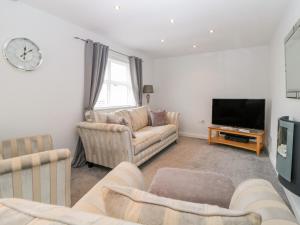 a living room with two couches and a tv at Fonthill in Torquay