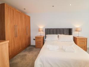 1 dormitorio con 1 cama blanca grande y 2 mesitas de noche en Fonthill en Torquay