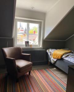 a bedroom with a bed and a chair and a window at Eleonora Bed & Breakfast in Kristinestad
