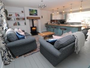 uma sala de estar com dois sofás e uma cozinha em Fox View Cottage em Hexham