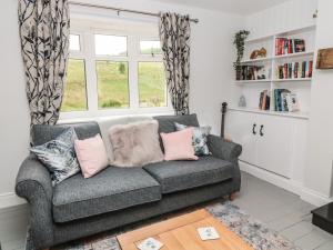 a living room with a couch and a window at Fox View Cottage in Hexham