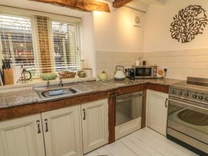 a kitchen with a sink and a microwave at Litton Hall Barn Cottage in Skipton