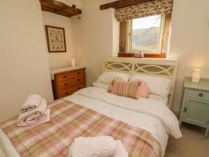 a small bedroom with a bed and a window at Litton Hall Barn Cottage in Skipton