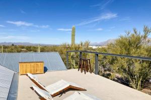 a deck with two chairs and a table and a cactus at Lazy C Ranch in Tucson