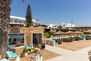 クリシ・アクティにあるGolden Beach Hotelのリゾートで、プール、テーブル、椅子を提供しています。