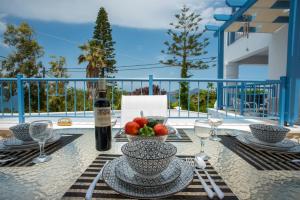 una mesa con una botella de vino y un bol de fruta en Villa Salomon BY APOKORONAS-VILLAS, en Plaka