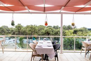een eetkamer met een tafel, stoelen en ramen bij Selin Otel Belek in Antalya