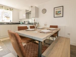 eine Küche und ein Esszimmer mit einem Tisch und Stühlen in der Unterkunft 4 Trerammet Crescent in Tintagel
