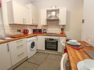 a kitchen with white cabinets and a stove top oven at 10 West Cottages in Oldham