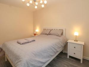 a bedroom with a bed with two lamps on it at 10 West Cottages in Oldham
