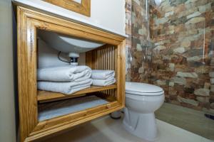 a bathroom with a toilet and a sink and towels at Casa Nikita in Vama Veche