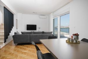 シベニクにあるHoliday home Villa Portaのソファとテーブルと椅子のあるリビングルーム