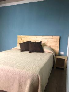 - une chambre avec un grand lit et un mur bleu dans l'établissement Casa Vacanze Il Vicolo - Oliveto Citra, à Oliveto Citra
