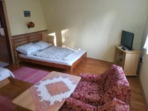 ein Schlafzimmer mit einem Bett, einem Sofa und einem Stuhl in der Unterkunft Szőnyi úti vendégház in Zebegény