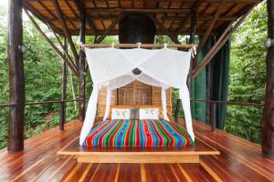 una cama en la cubierta de una casa en un árbol en Surfers´bohemian dream overlooking the point break, en Cabo Matapalo