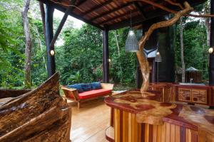 una sala de estar al aire libre con una mesa de tocón de árbol. en Surfers´bohemian dream overlooking the point break, en Cabo Matapalo