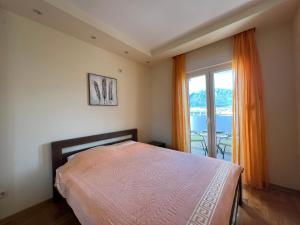 a bedroom with a bed and a large window at Apartment SeaView in Bar