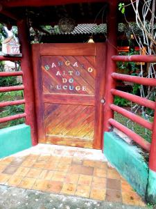 uma porta de garagem de madeira com um sinal em Bangalô alto do Mucugê em Arraial d'Ajuda