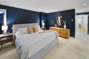 a bedroom with a large bed and a blue wall at Beachside Living Cherry Point in Cobble Hill