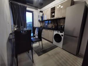 a kitchen with a table and a refrigerator at Lumandi LS residence in Mamaia Nord +6 photos