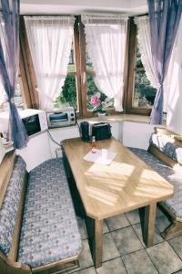 einen Tisch und Stühle in einem Zimmer mit Fenstern in der Unterkunft Ferienwohnung Am Forstamt in Ramsau bei Berchtesgaden