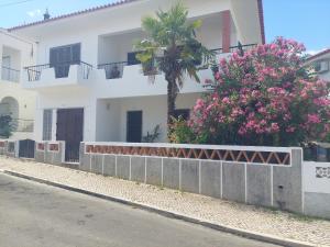 a white building with a palm tree and pink flowers at ELEVEN -A- SUITE tipo T1 in Mértola