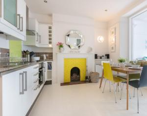 a kitchen with a table and a yellow fireplace at The View in Port Isaac