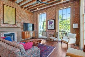 a brick room with a couch and a fireplace at Fab 1838 Garden District 5BR with Parking And Balcony in New Orleans
