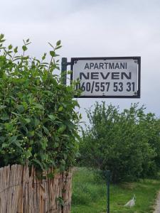 a sign that says aprilani newlyn next to a bush at Apartmani Neven in Irig