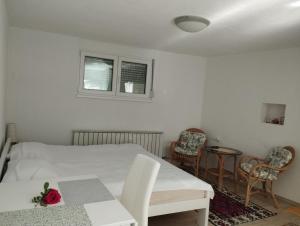 a bedroom with a bed and two chairs and a table at Apartman Medrese in Sarajevo +9 photos