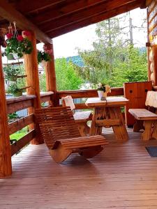 drewniany ganek ze stołem i ławkami w obiekcie Tylickie Chałupy w mieście Tylicz