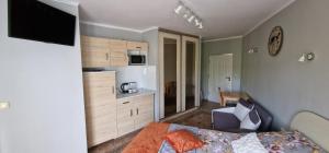 a small bedroom with a bed and a kitchen at Apartamenty Hexagon nr 25 in Grzybowo