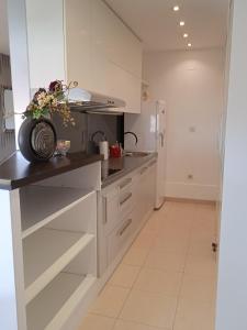 Una cocina con gabinetes blancos y un refrigerador. en Dreams Apartment Bacvice, en Split