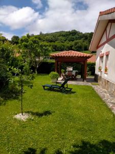 ein Garten mit Picknicktisch und Pavillon in der Unterkunft Chalet Kuki in Ribas