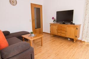 a living room with a couch and a tv on a cabinet at Ferienwohnung Am Forstamt in Ramsau