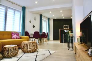 a living room with a yellow couch and a table at La Loge en Or - Parking public - Triplex - Proche centre et autoroute in Lens