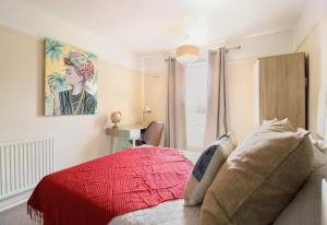 a bedroom with a red bed and a desk at Virexxa Aylesbury Centre - Executive Suite - 2Bed Flat with Free Parking in Aylesbury