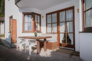 a wooden table and chairs in front of a house at Ferienwohnung Am Forstamt in Ramsau