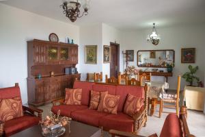 a living room with a red couch and a table at Eleni's House Chorefto in Zagora