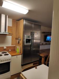 a kitchen with a stainless steel refrigerator and a stove at Helt i Vannkanten as in Åkrehamn +9 photos